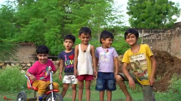 インドのラージャスターン州シカリ 2222年9月 写真を撮るために走っているインドの子供たちのグループ 幸せなインドの田舎の少年と少女 インドの農村部の人々は日常生活を送っています インドの小さな村の幸せな笑顔のグループ — ストック動画