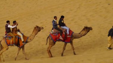 Jaisalmer, Rajasthan, Hindistan - Kasım 2022: Sam Sand Dunn 'da deve biniciliği. Bu etkinlik, hem yerli hem de yabancı turistleri çekmek amacıyla kışın düzenlenen Çöl Festivali kapsamında gerçekleşti..