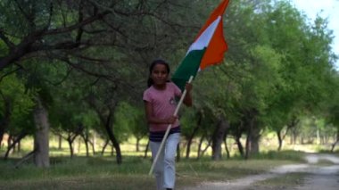 Sarılan, el sallayan ya da arka planda yeşillik olan bir tepenin yanında koşan, Bağımsızlık Günü 'nü ya da Cumhuriyet Günü' nü kutlayan sevimli küçük Hintli kız.