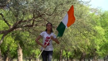 Sarılan, el sallayan ya da arka planda yeşillik olan bir tepenin yanında koşan, Bağımsızlık Günü 'nü ya da Cumhuriyet Günü' nü kutlayan sevimli küçük Hintli kız.