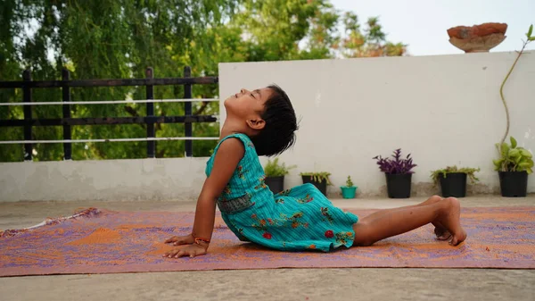Güzel bir öğrenci yoga yapıyor ya da evde alıştırma yapıyor. Evde uluslararası yoga günü kutlaması