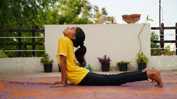 Klein Schattig Meisje Oefenen Yoga Pose Een Mat Indoor — Stockfoto