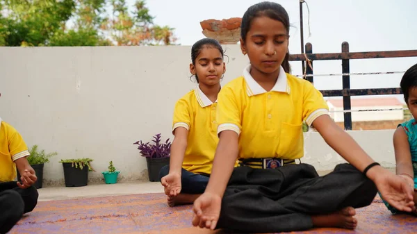 两个印度小女孩在公园里闭着眼睛 在滚石垫子上冥想瑜伽 在室外练习瑜伽的小女孩 — 图库照片