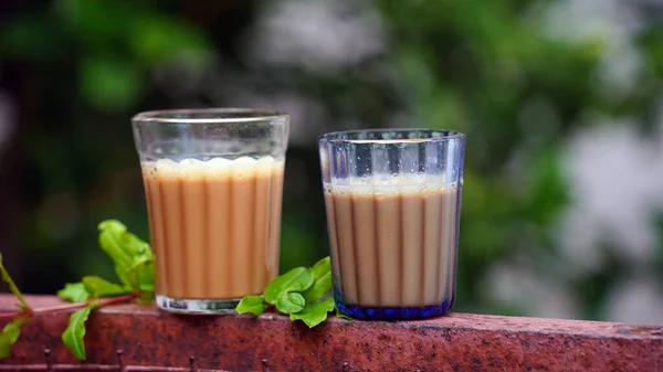 ミルクティー お茶チャイ伝統的な飲料を注ぐ オーガニックアーユルヴェーダまたはハーブドリンクインドの2つのガラス 免疫力を高めるために冬に良いお茶 フレッシュミルクティーまたはインドのカダックチャイ — ストック写真