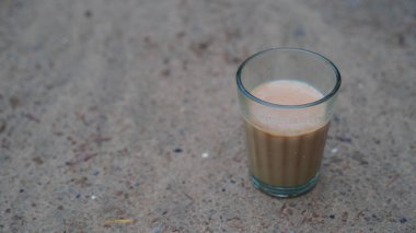 Bir fincan taze demlenmiş siyah çay, buhardan kaçan sıcak yumuşak ışık, daha koyu arkaplan. Taze süt çayı ya da Hint Kadak Chai. Masala çayı.