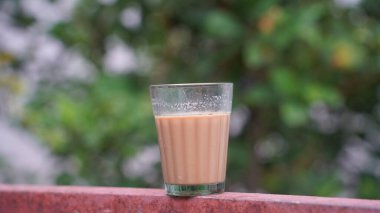 Bir fincan taze demlenmiş siyah çay, buhardan kaçan sıcak yumuşak ışık, daha koyu arkaplan. Taze süt çayı ya da Hint Kadak Chai. Masala çayı.