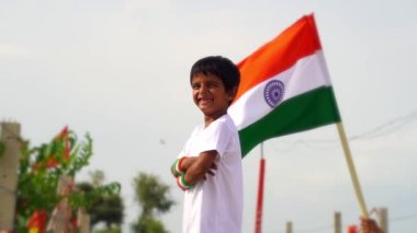 Beyaz arka planda izole edilmiş Hindistan Ulusal Bayrağı 'na sahip şirin küçük bir çocuk. Bağımsızlık Günü ya da Cumhuriyet Günü konseptine uygundur