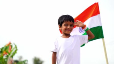 Hindistan 'da küçük şirin bir çocuk beyaz tişört giyiyor, elinde üç renkli Hint bayrağı, Cumhuriyet Günü' nü, Bağımsızlık Günü 'nü, Hindistan' ı kutluyor.