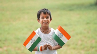 Kızılderili bayrağı tutan Hintli çocuğun yakın görüntüsü. Bağımsızlık Günü 'nü ya da Hindistan Cumhuriyeti' ni kutlamak