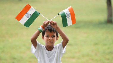 Kızılderili bayrağı tutan Hintli çocuğun yakın görüntüsü. Bağımsızlık Günü 'nü ya da Hindistan Cumhuriyeti' ni kutlamak