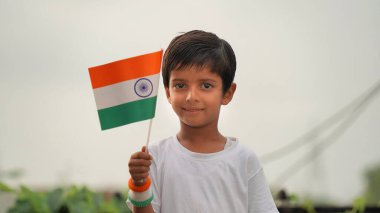 Kızılderili bayrağı tutan Hintli çocuğun yakın görüntüsü. Bağımsızlık Günü 'nü ya da Hindistan Cumhuriyeti' ni kutlamak