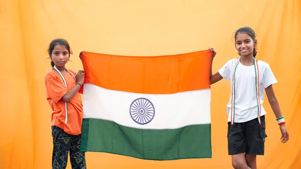Little Indian village girls proudly holds the tricolour Indian flag. Teenager holding national flag