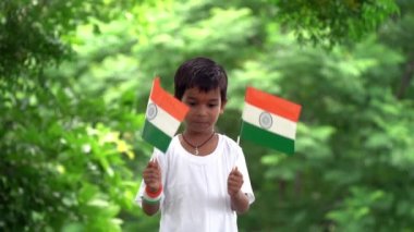 Küçük Kızılderili köylü çocuk gururla üç renkli Hint bayrağını taşıyor. Ulusal bayrak taşıyan genç