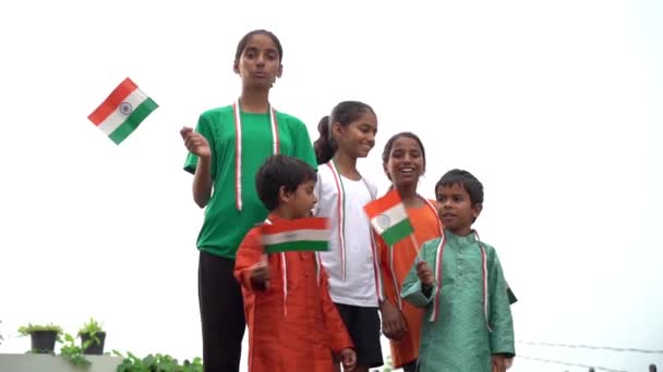 印第安小村的女孩和男孩自豪地举着印度三色旗 悬挂国旗的青少年 — 图库视频影像