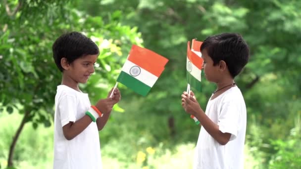 インドの小さな子供たちは誇らしげにトリコロールのインドの国旗を持っています 国旗を掲げるティーンエイジャー — ストック動画