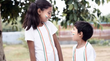 Bağımsızlık Günü 'nde Hindistan bayrağını boynunda taşıyan küçük kız ve oğlan.