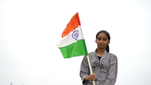 インドの若い女の子は バックグラウンドで緑とトリコロールを保持 振ったり走ったり 独立または共和国の日を祝います — ストック動画