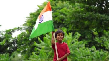 Sevimli küçük Hintli çocuklar el sallıyor ya da arka planda yeşillik ile koşuyorlar Bağımsızlık Günü 'nü ya da Cumhuriyet Günü' nü kutluyorlar.