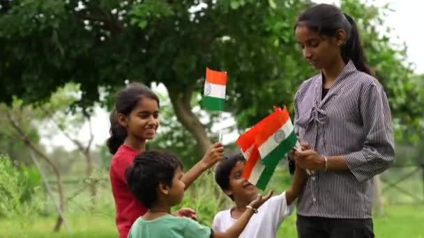 緑豊かなトリコロールを背景に 独立記念日や共和国の日を祝うかわいいインドの子供たち — ストック動画