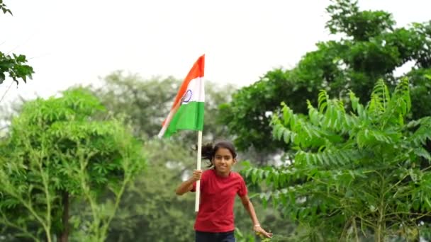 かわいい小さなインドの子供は バックグラウンドで緑色のトリコロールと握ったり 振ったり 走ったり 独立や共和国の日を祝います — ストック動画
