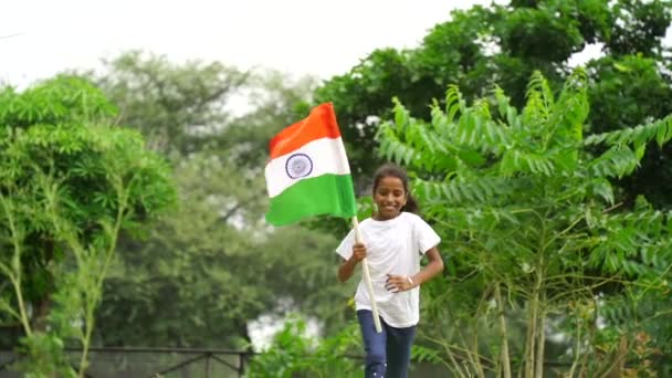 Cute Little Indian Kid Holding Waving Running Tricolour Greenery Background — Stock Video