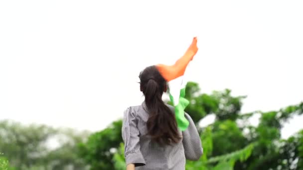 かわいい若いインドの少女は バックグラウンドで緑とトリコロールを保持 振ったり 走ったり 独立または共和国の日を祝います — ストック動画