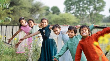 Bir grup neşeli Hintli çocuk bahar parkında oynuyorlar. Asyalı çocuklar bahçede oynuyorlar. Yaz tatili.