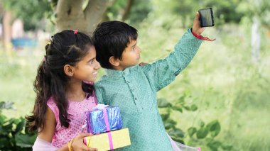 Etnik gruptaki küçük kardeşler, Raksha Bandhan festivali kutlamalarında selfie çekiyorlar.  