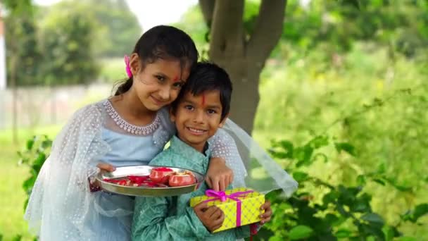 かわいい小さなインディアン姉妹はラクシャ バンダンやブーイ ドーホーフェスティバルでラクシャの手首にラクシを結び 贈り物やお菓子を交換する — ストック動画
