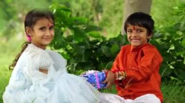 Sevimli Hintli kız ve erkek kardeş Raksha Bandhan festivalini ya da Bhai Dooj 'u hediyelerle kutluyor.