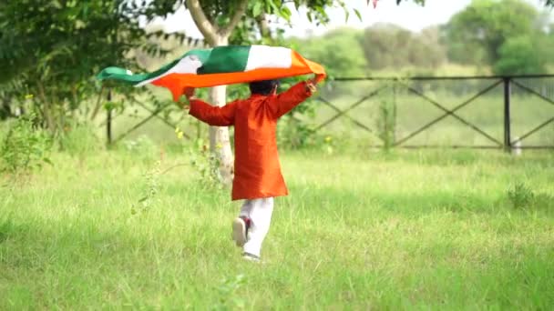 在绿色的背景上 一个可爱的印度小男孩拿着印度三色旗跑步 庆祝独立日或印度共和国日 — 图库视频影像