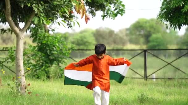 Söt Liten Indian Pojke Kör Med Indiska Tricolour Flagga Grönska — Stockvideo