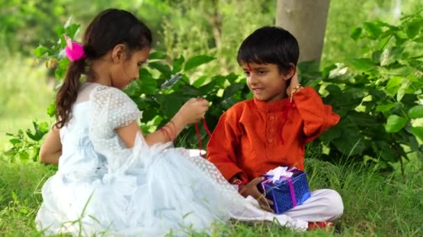 Happy Cute Indian Girl Tying Rakhi Brother Hand Raksha Bandhan — Stock Video