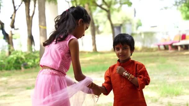 Słodkie Indyjski Dziewczyna Sukienka Wiąże Bransoletka Dla Jego Młodszy Brat — Wideo stockowe