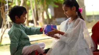 Sevimli Hintli kız ve erkek kardeş Raksha Bandhan festivalini ya da Bhai Dooj 'u hediyelerle kutluyor.