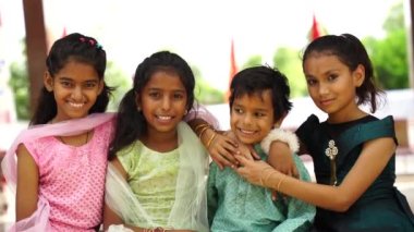 Geleneksel Hint kıyafeti giyen küçük çocuklar Hint festivalinin tadını çıkarıyorlar. Etnik sınıftan çocuklar kameraya bakıyor.
