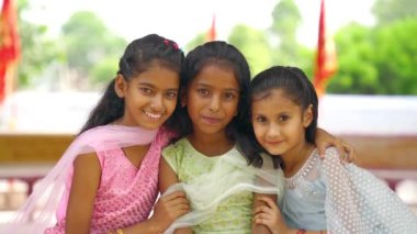 Geleneksel Hint kıyafeti giyen küçük çocuklar Hint festivalinin tadını çıkarıyorlar. Etnik sınıftan çocuklar kameraya bakıyor.