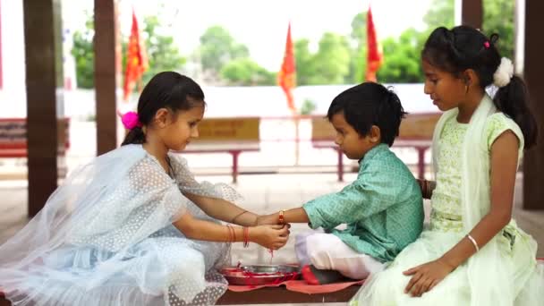 Fofa Pequena Irmã Indiana Amarrando Rakhi Pulso Seu Irmão Mais — Vídeo de Stock