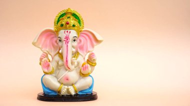 Hindu tanrısı Ganesha 'nın heykeli pembe arka planda. Ganesh Chaturthi Festivali 'ni kutlayın.