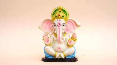 Hindu tanrısı Ganesha 'nın heykeli pembe arka planda. Ganesh Chaturthi Festivali 'ni kutlayın.