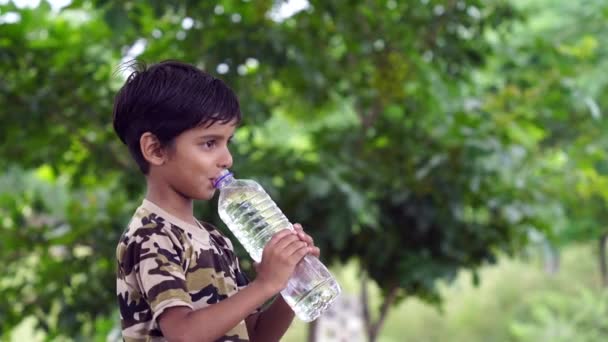 Boldog Aranyos Indiai Fiú Fekete Hajjal Ivóvíz Parkban Kezében Műanyag — Stock videók