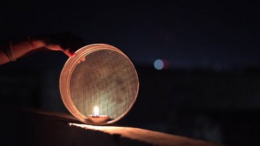 Genç Hintli kadın gece Karva Chauth 'u kutluyor. Karva Chauth, Hindistan 'da Kartika ayından dört gün sonra Hindu kadınlar tarafından kutlanan bir günlük festivaldir..