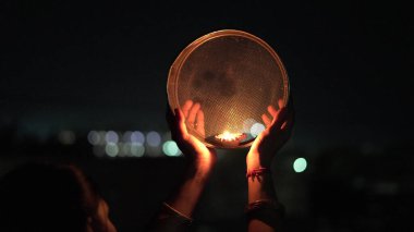 Genç Hintli kadın gece Karva Chauth 'u kutluyor. Karva Chauth, Hindistan 'da Kartika ayından dört gün sonra Hindu kadınlar tarafından kutlanan bir günlük festivaldir..