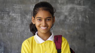 Mutlu Hintli ilkokul öğrencileri sınıfta masalarında oturup kalemle, sınavla, kadın eğitim konseptiyle not defterine yazıyorlar..