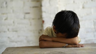 Sınıfta masa başında oturan mutlu Hintli okul çocuğunun portresi. Kalemleri ve defterleri olan okul öğrencileri. İlkokul, eğitim konsepti..