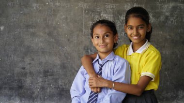 Sınıfta masa başında oturan mutlu Hintli okul çocuğunun portresi. Kalemleri ve defterleri olan okul öğrencileri. İlkokul, eğitim konsepti..