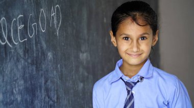 Siyah karatahtanın önünde duran mutlu Hintli kız öğrenci. Eğitim Konsepti veya Okula Dönüş