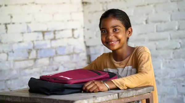 Portrait of happy indian school child sitting at desk in classroom, school kids with pens and notebooks writing test Elementary school, Education concept.