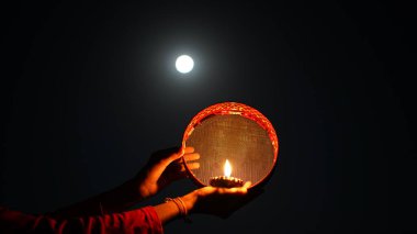 Genç Hintli kadın gece Karva Chauth 'u kutluyor. Karva Chauth, Hindistan 'da Kartika ayından dört gün sonra Hindu kadınlar tarafından kutlanan bir günlük festivaldir..