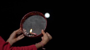 Genç Hintli kadın gece Karva Chauth 'u kutluyor. Karva Chauth, Hindistan 'da Kartika ayından dört gün sonra Hindu kadınlar tarafından kutlanan bir günlük festivaldir..